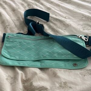 Turquoise belt bag is a lululemon Travel Pooch Bag designed for dog walking🐾